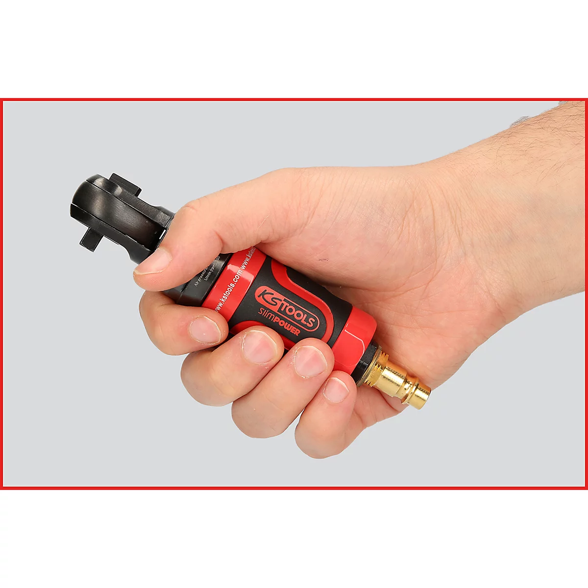 Eine Person hält einen roten und schwarzen Druckluftratschenschlüssel in der Hand. Der Schlüssel ist deutlich sichtbar.